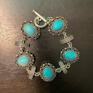 Oval shaped turquoise inspired charm bracelet, with toggle enclosure.